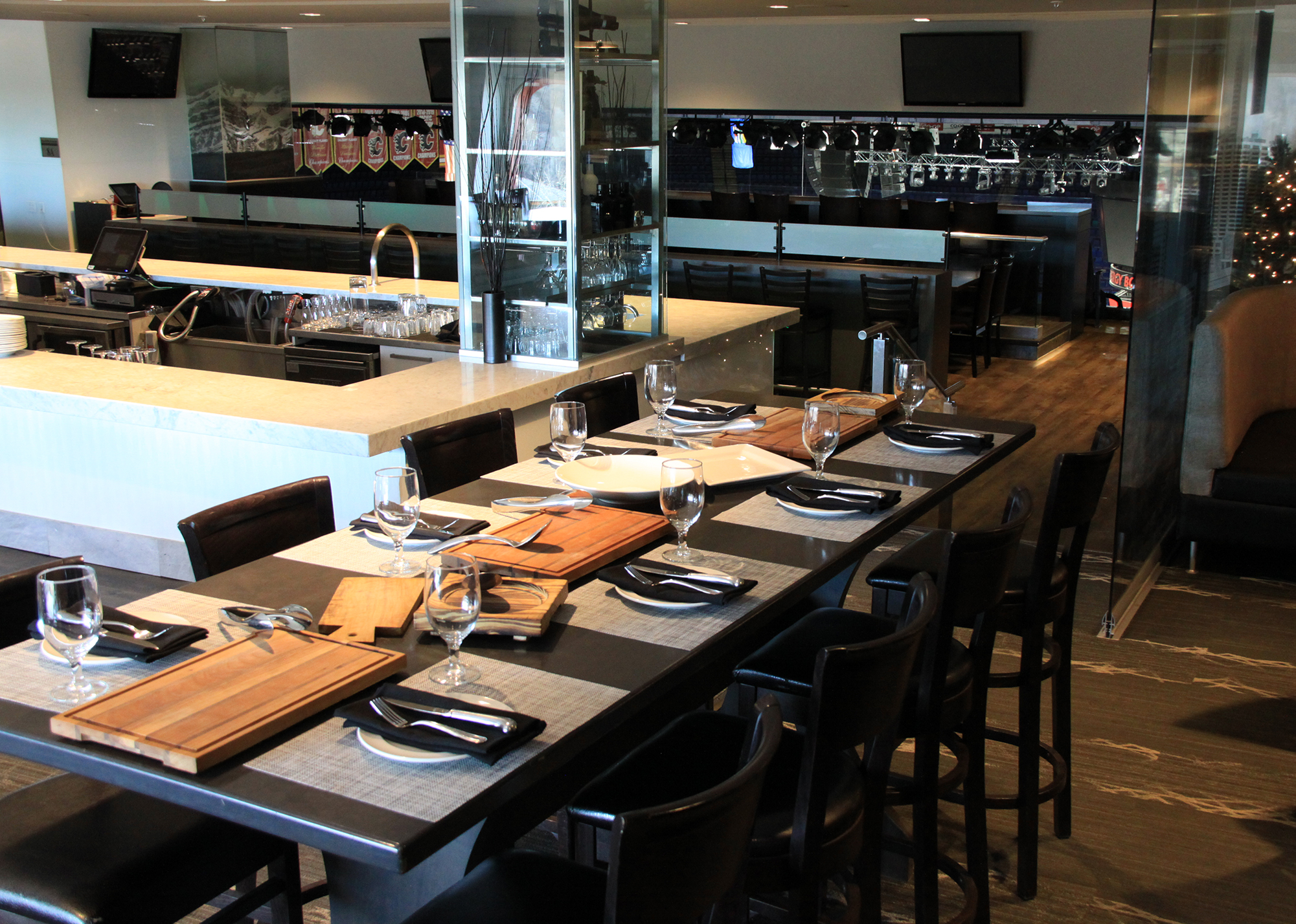 Inside the Saddleroom Grill restaurant, tables are set with cutting boards, place mats, cutlery, plates and glasses