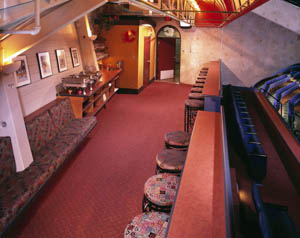 Stools are set along a bartop in an empty restaurant