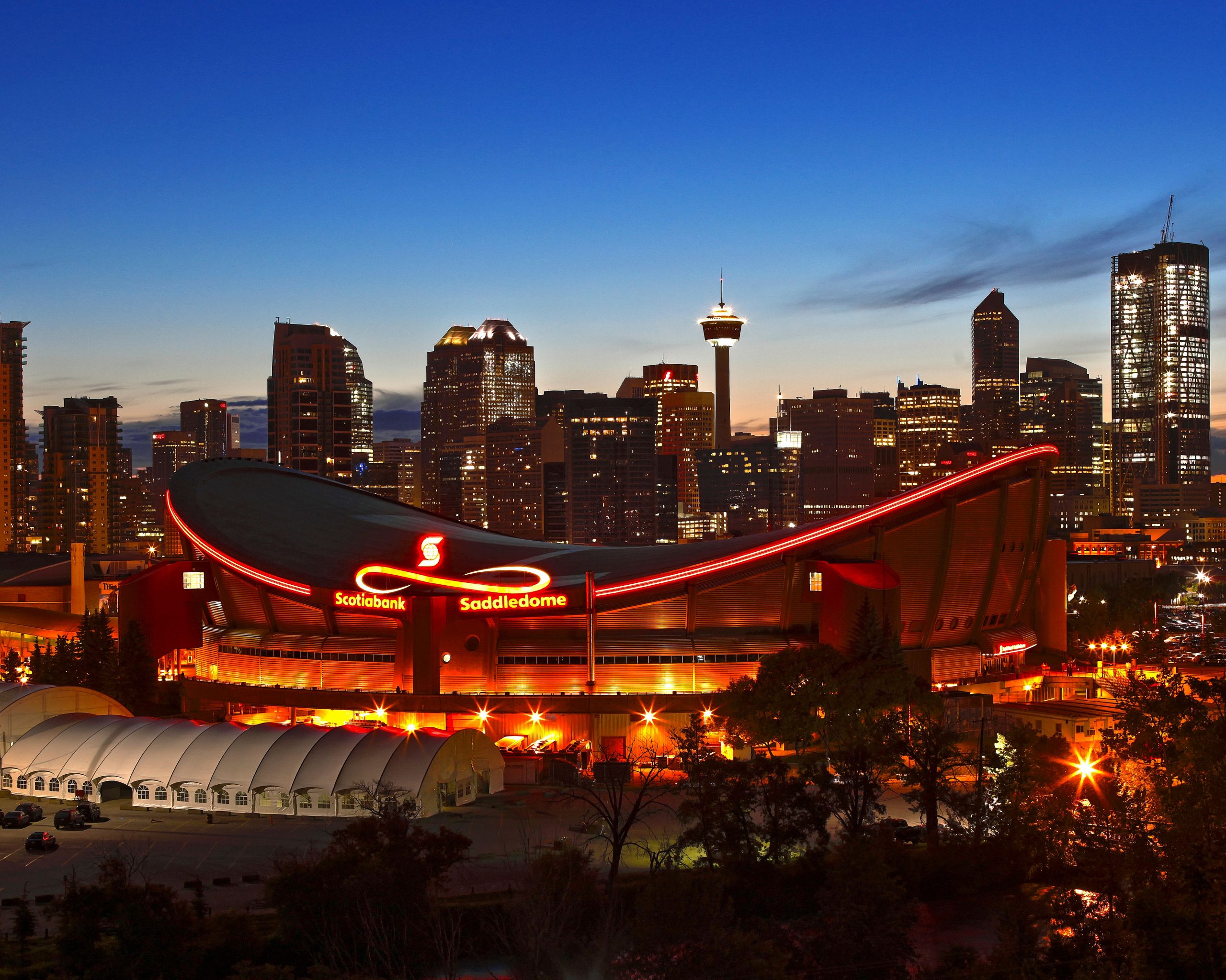 Scotiabank Saddledome in the foreground, downtown Calgary in the background during the evening
