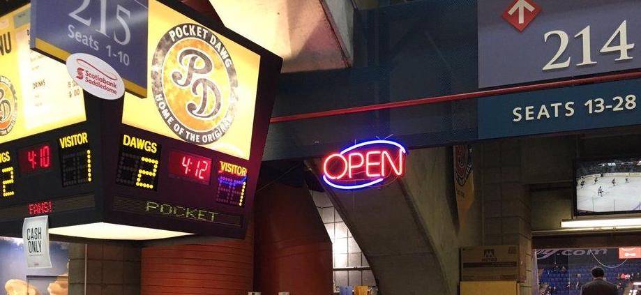 A lit up sign with the Pocket Dawg logo on it inside the Scotiabank Saddledome concourse area